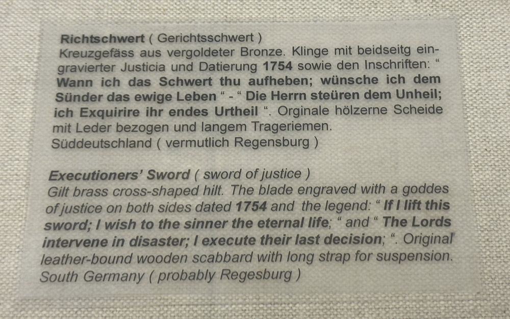 Photo of another sword from 1754 labeled with a similar inscription translated from German: "The Lords intervene in disaster; I execute their last decision" and "If I lift this sword; I wish to the sinner the eternal life".