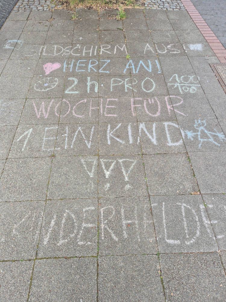 Pflastermalerei: "Bildschirm aus, Herz an. 2h pro Woche für ein Kind."