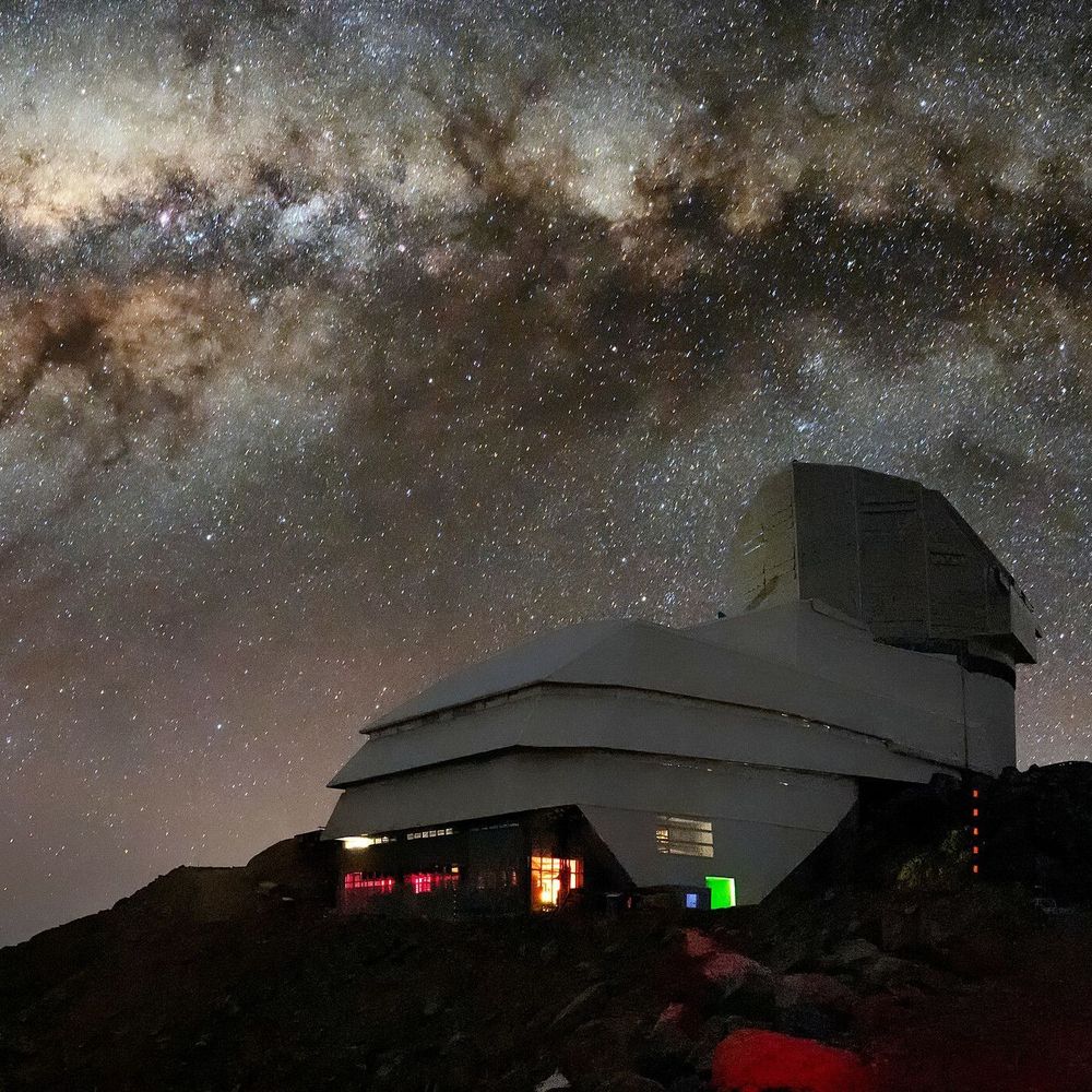 Composite photograph of the NSF-DOE Vera C. Rubin Observatory at night with the plane of the Milky Way above, which is full of gas and dust and stars and nebulae.