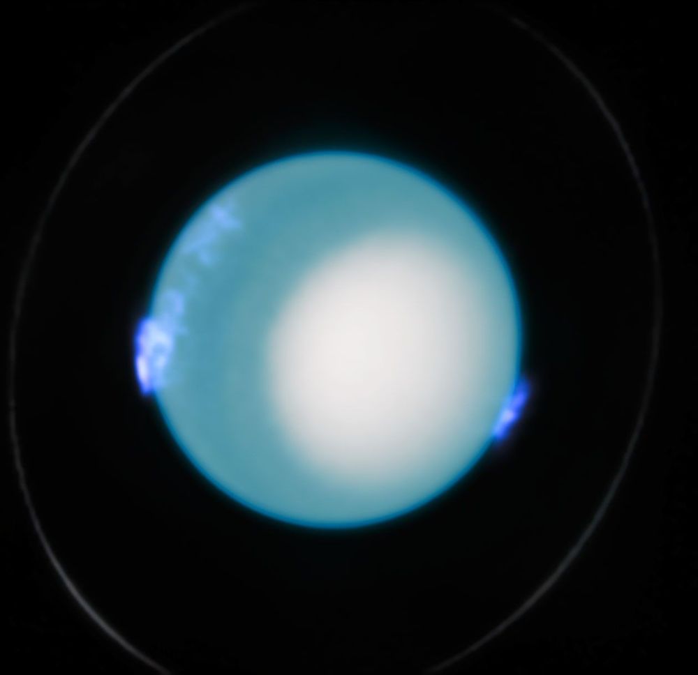 Photo of Uranus taken by the Hubble Space Telescope, showing a blue orb that glows with blue aurorae at the nine and four o'clock positions. A faint ring can be seen around the planet, reaching nearly the edges of the image.