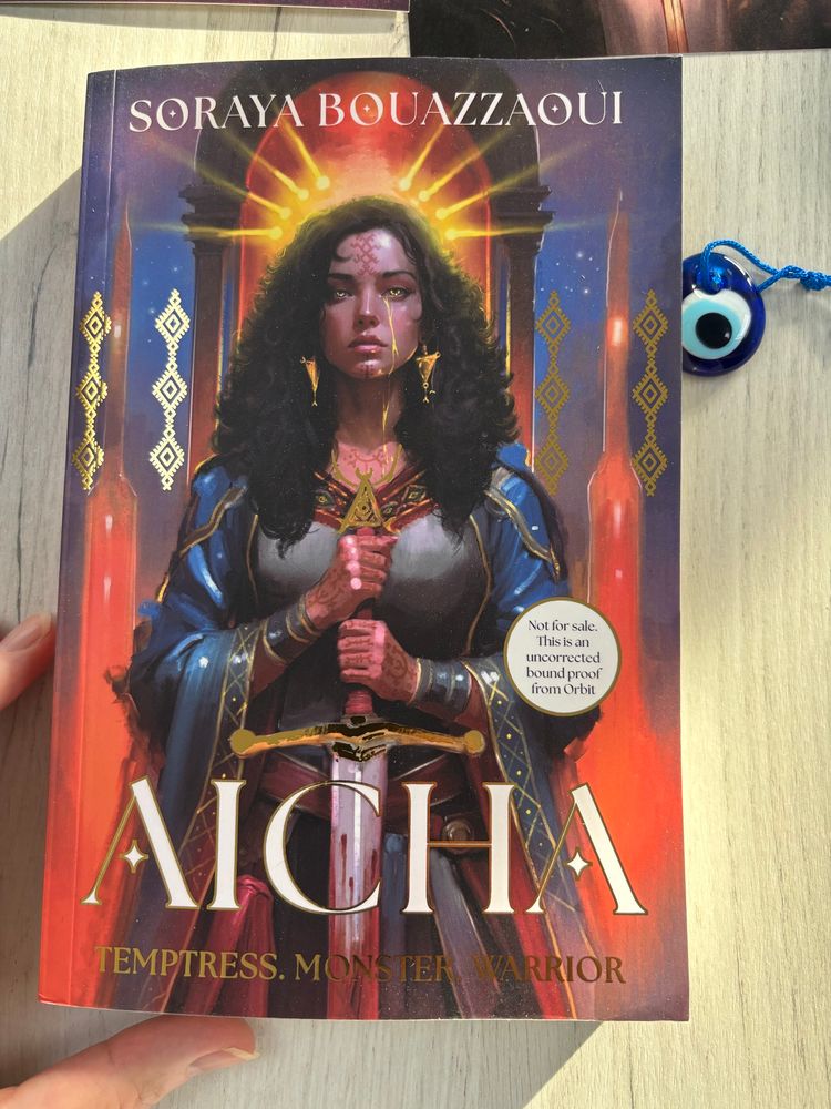 Cover for Aicha by Soraya Bouzzaoui shows a woman holding a sword with golden tear down her face 