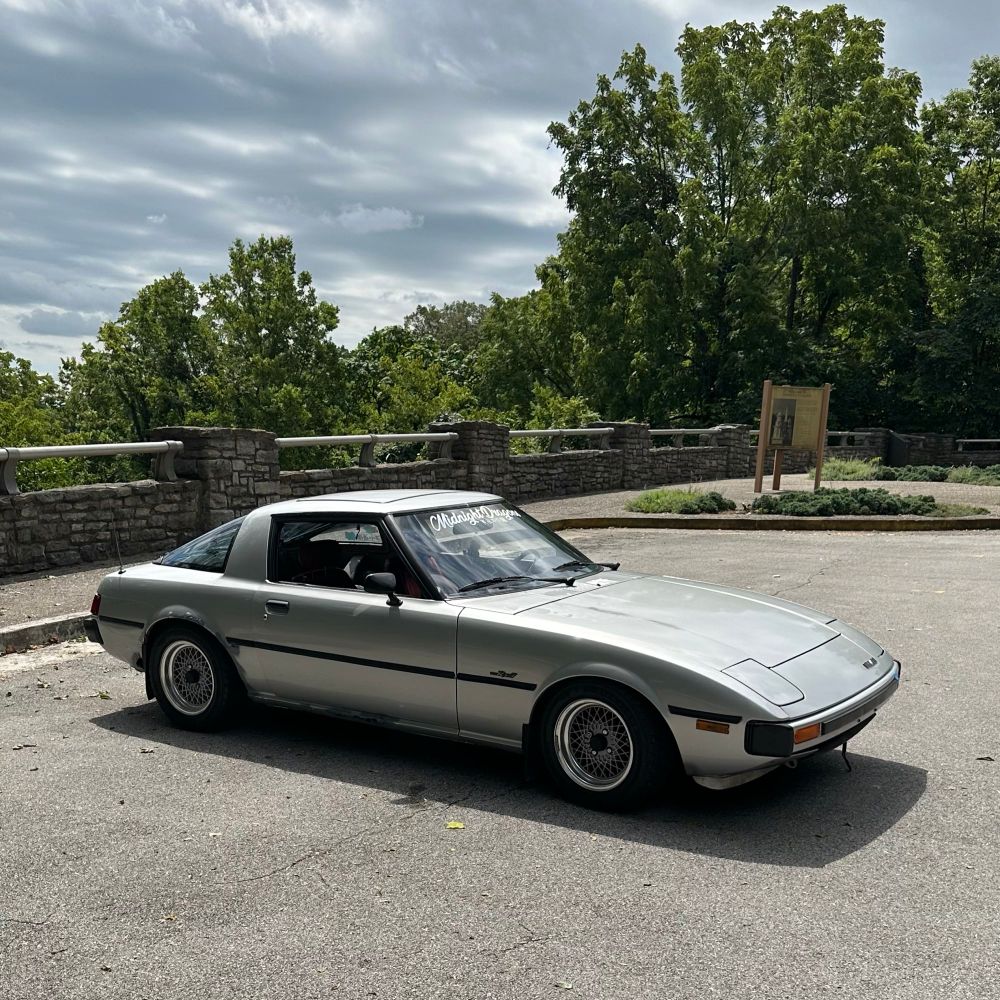 picture of a silver FB rx7 parked at a scenic overlook. 