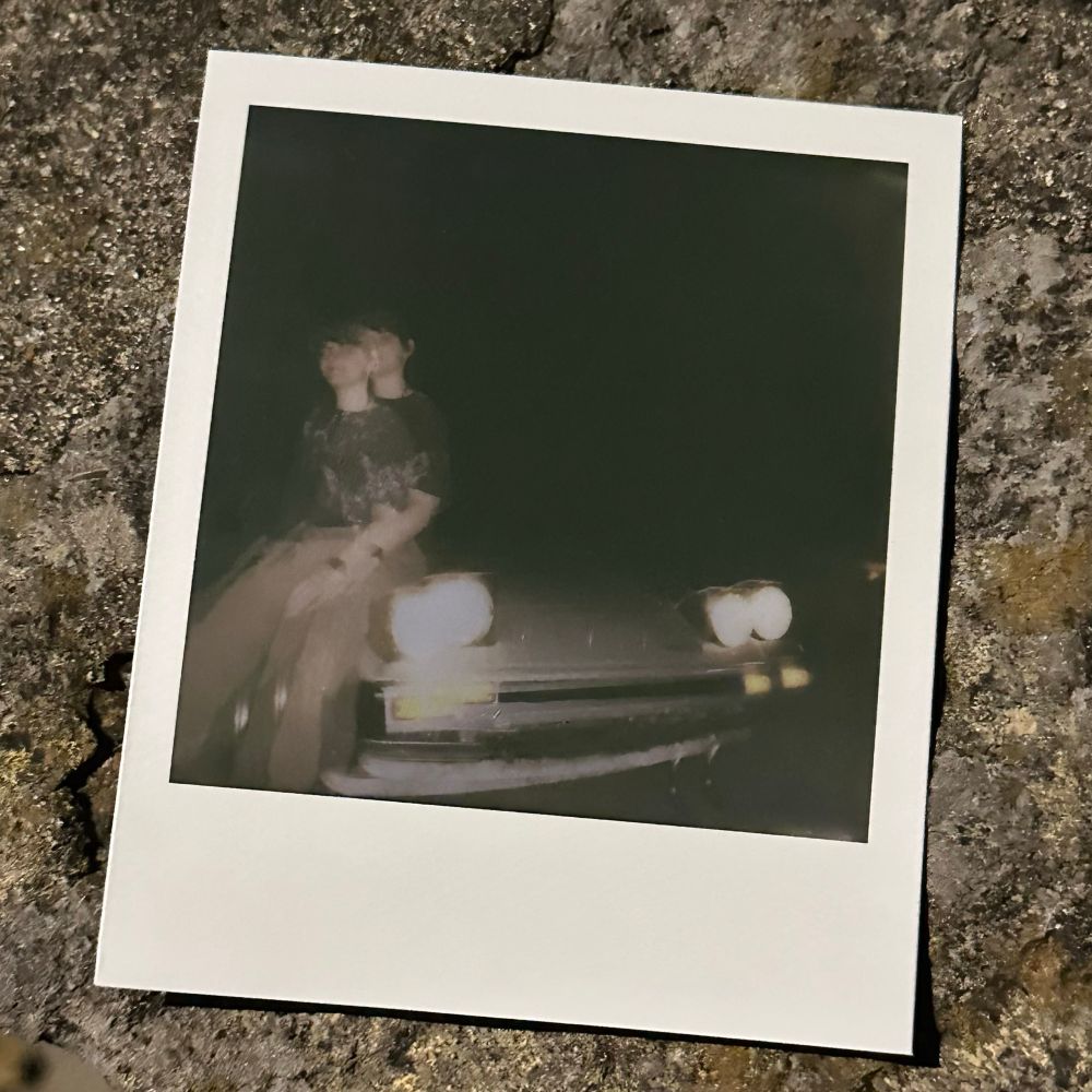 double exposed polaroid picture of Fisher sitting on the front of their Fb rx7. 