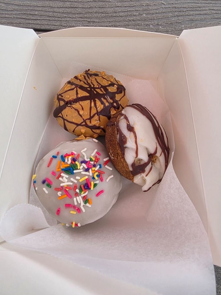 3 donuts in a box, peanut butter, white chocolate, and glazed sprinkles 