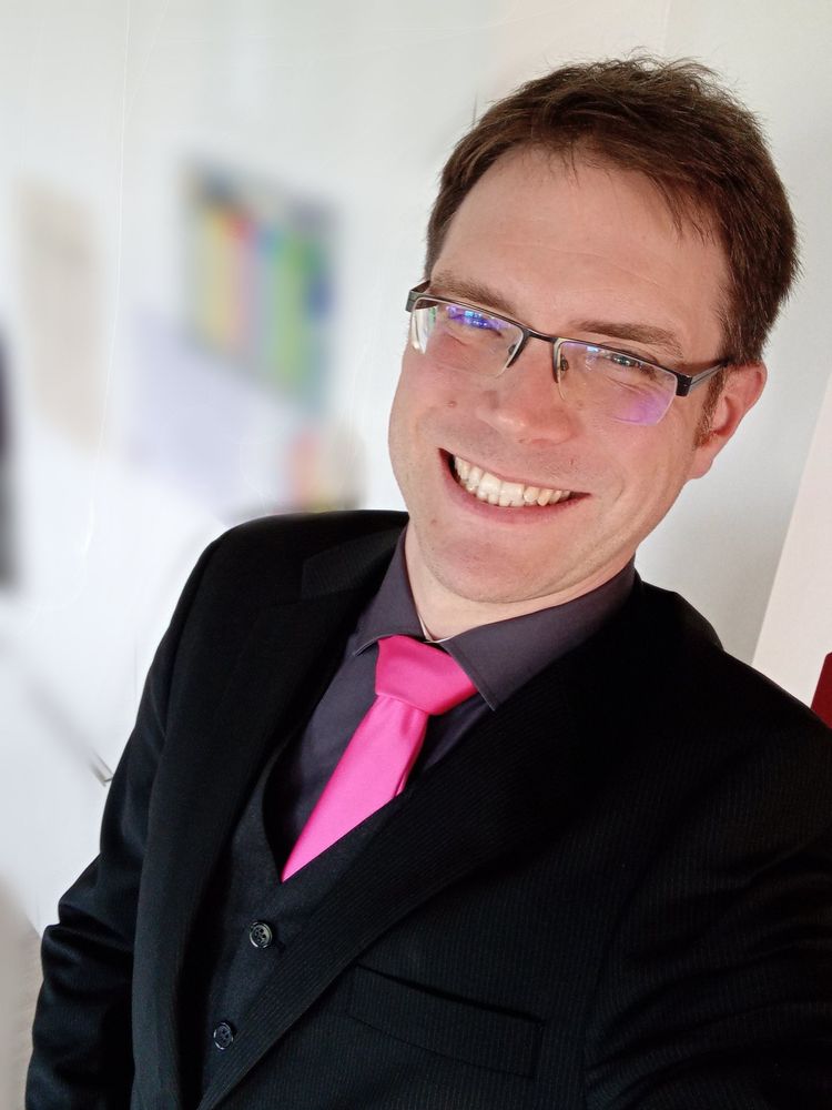 Self portrait of me, a middle aged white man. I'm wearing a dark grey shirt, pink tie, charcoal vest and black suit jacket.