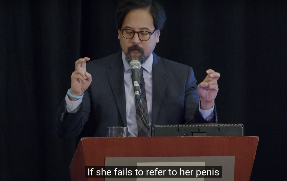 An image of Wesley Yang talking at some conference or other, with the closed caption text included. It reads, "If she fails to refer to her penis..."
