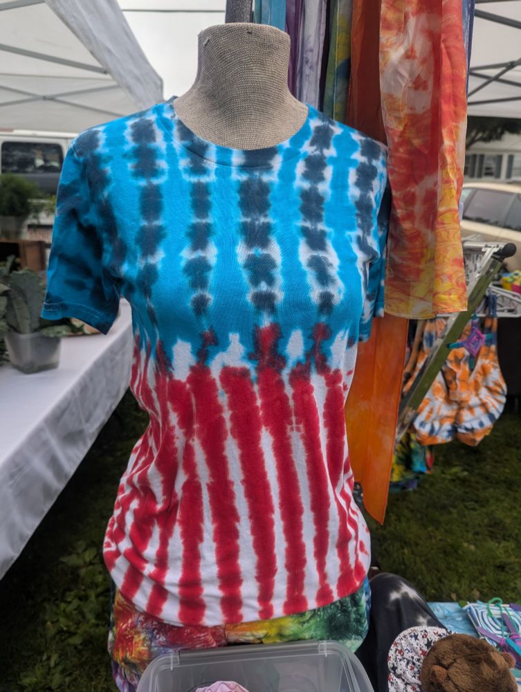 Headless mannequin wearing a tie dye red, white and blue shirt