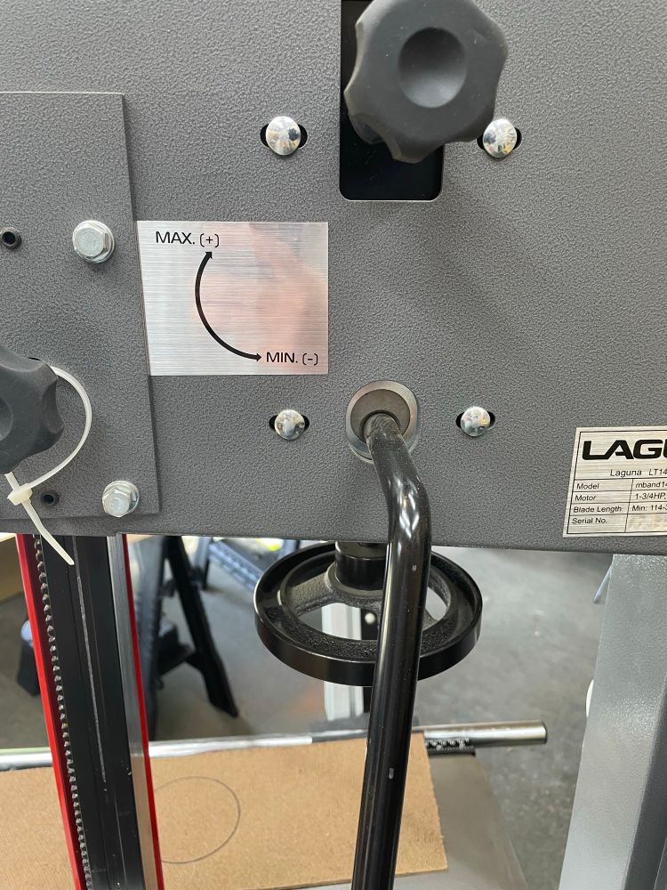 Picture of a bandsaw blade tensioning arm set to the no tension setting.

