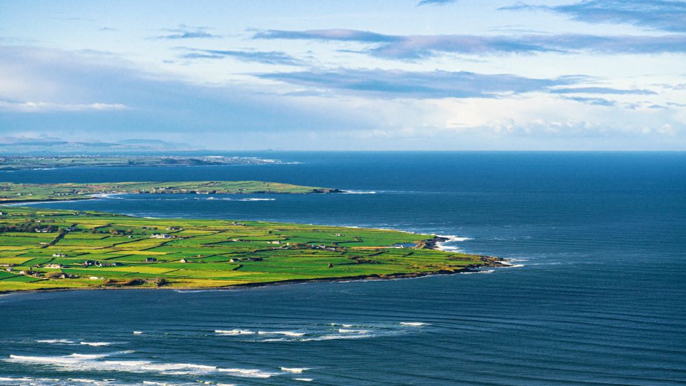 The northwest coastline of ireland, green fields and incoming waves from the atlantic ocan