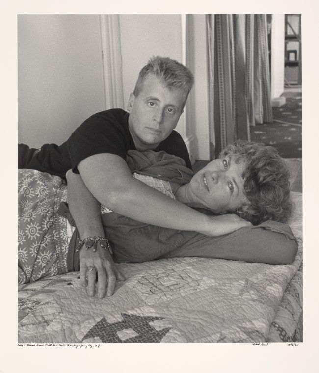 Black and white photo of Leslie Feinberg and Minnie Bruce Pratt laying on a bed together.
