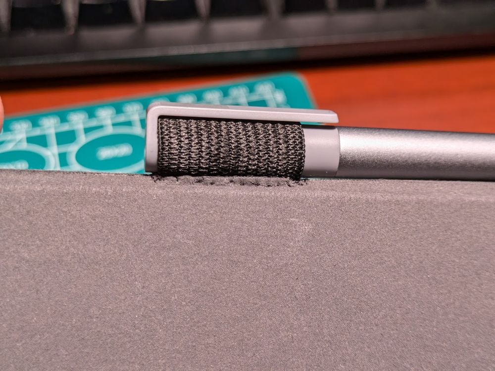A close-up of the interior side of the tablet case with the newly-sewn-in elastic loop for holding the tablet pen - this time with the pen securely within the loop.