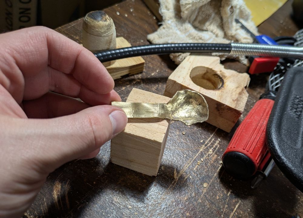 A horrible attempt at trying to form a brass spoon, after brushing off some of the soot and oxidation.