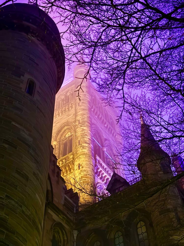Glasgow uni tower in the fog, illuminated by a purple light