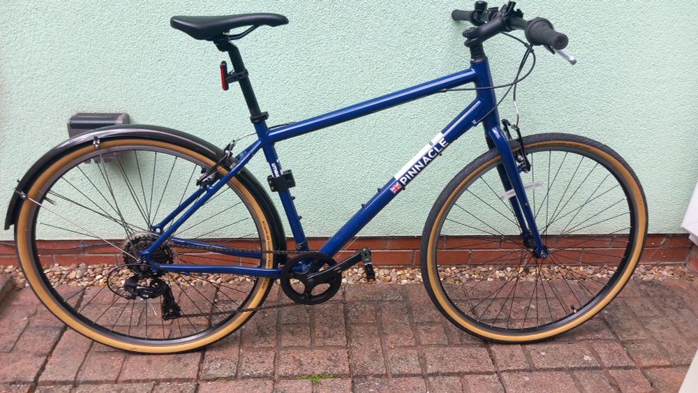 Bicycle with dark blue frame and amber tan wall tyres.