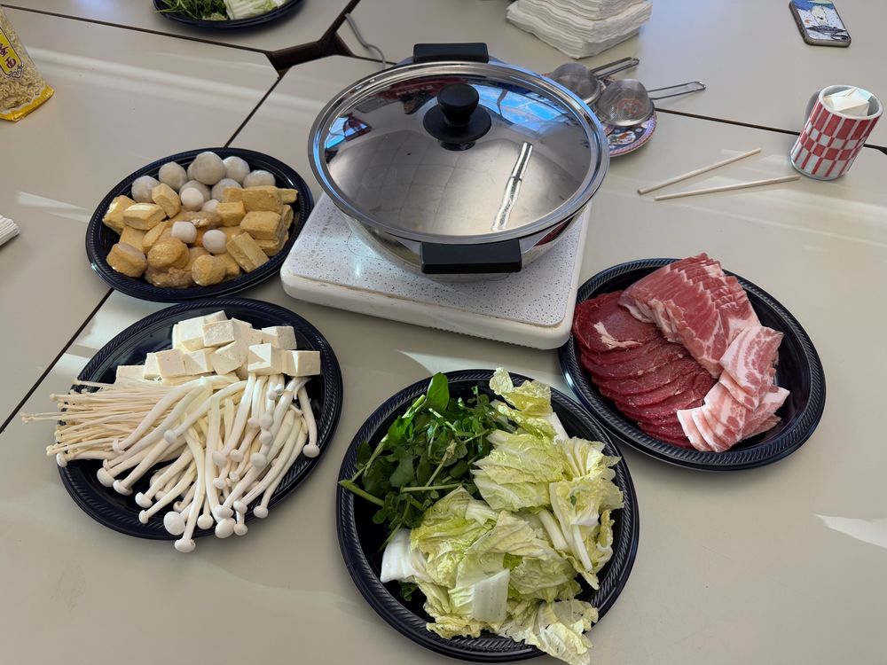 Hot pot with 4 plates of foods. Meat, veggies, mushrooms and fishballs