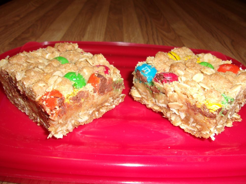 Two peanut butter dream bars on a red surface.  