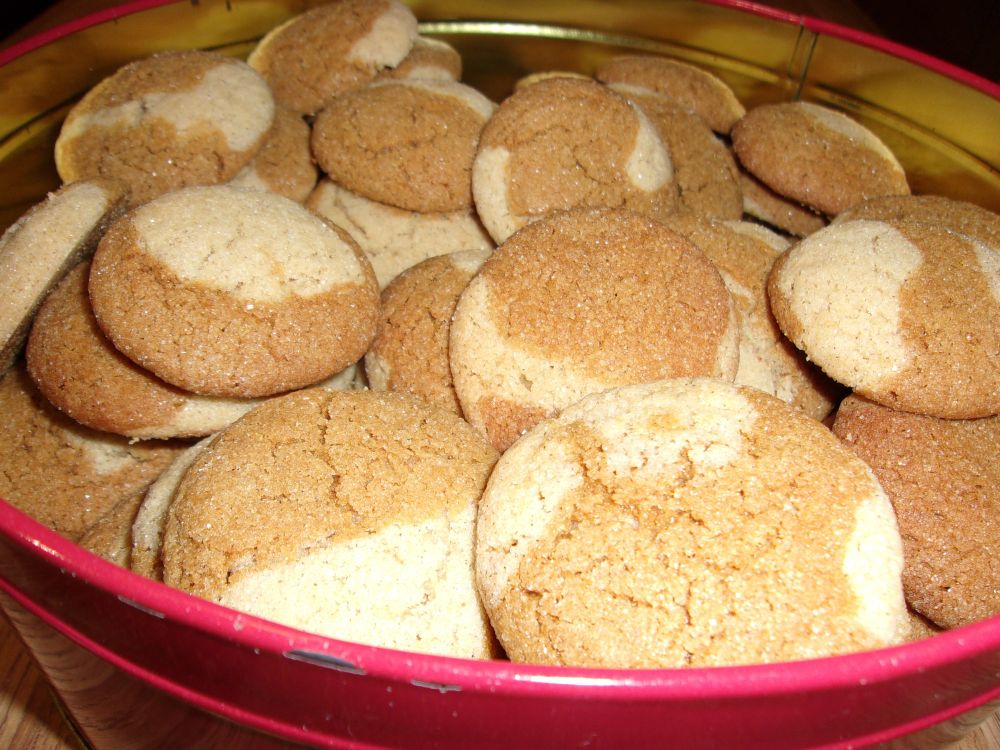 Red cookie tin filled with gingerdoodle cookies, which are half gingersnap and half snickerdoodle.