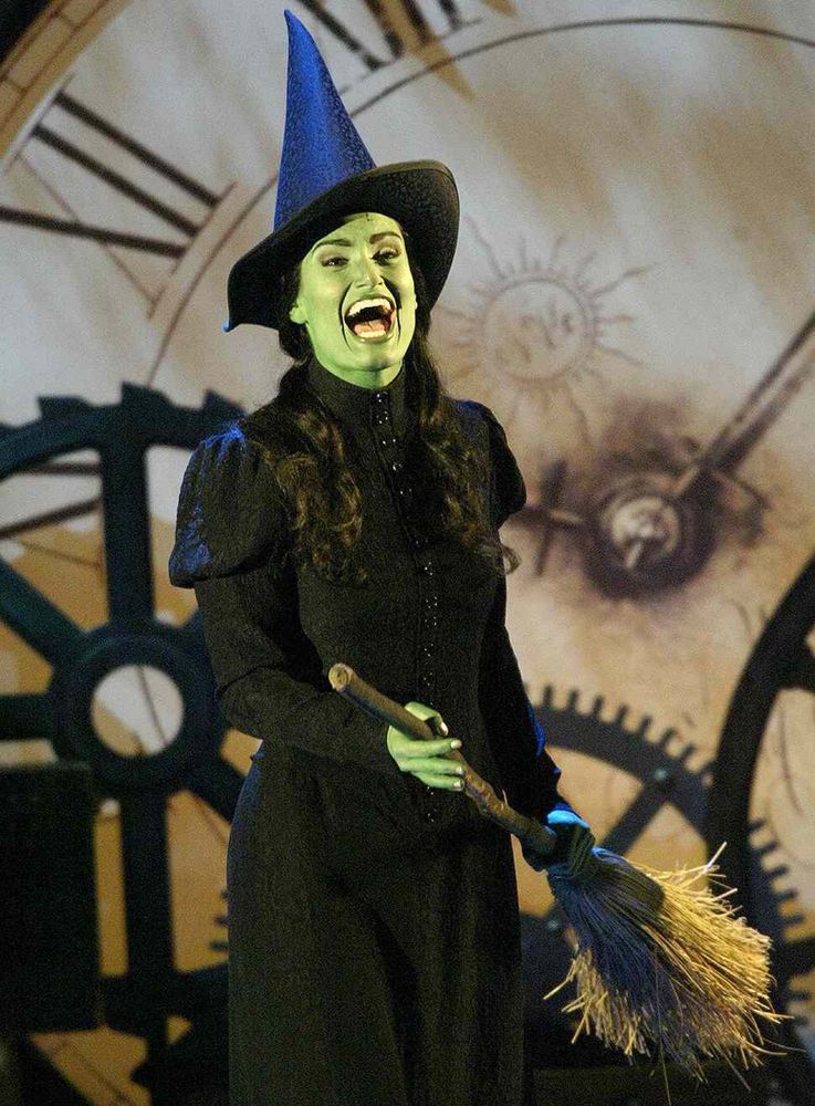 Elphaba as played by Idina Menzel (green woman in a witch costume) who, like me, takes questionable fashion advice from my better dressed friends. 