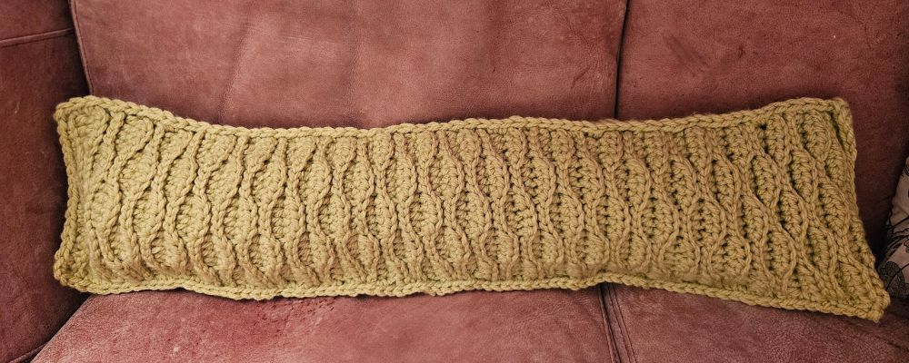 A pistachio-coloured, chunky yarn, crocheted draught excluder sitting on my cappuccino coloured sofa. The stitch texture is reminiscent of the bark of an elm tree. Pattern by Bella Coco, mistakes all my own
Yarn, Stylecraft special super chunky in Pistachio.