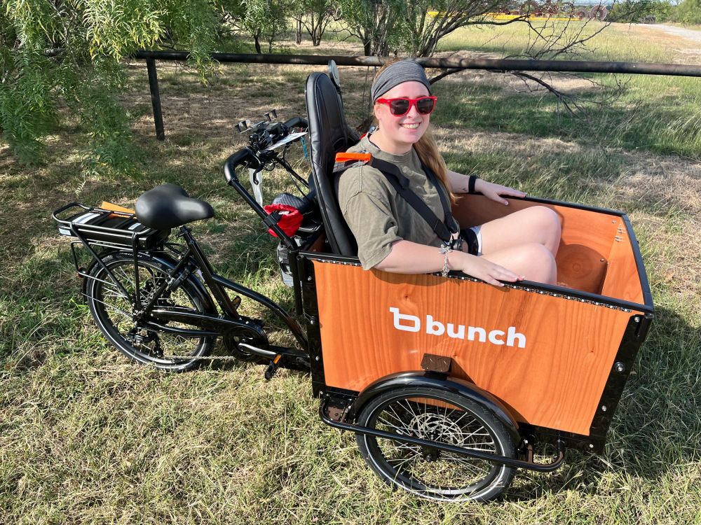Adult in sunglasses seated in go kart seat in the bunch bike