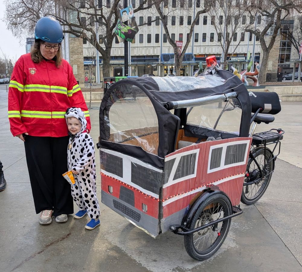 bunch bike dressed up as fire truck with mom dressed as firefighter and toddler dressed as dalmation
