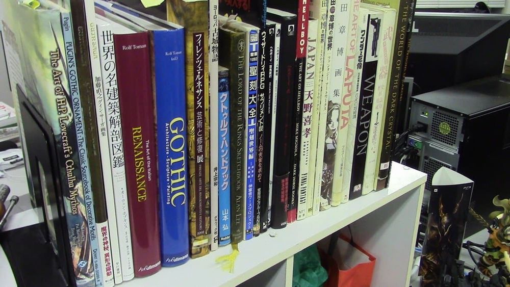 a shelf of books featuring reference and art books for Gothic Architecture, Cthulhu, Guin Saga, WARES BLADE, Wizardry, Hellboy, Final Fantasy, and the art of Akihiro Yamada