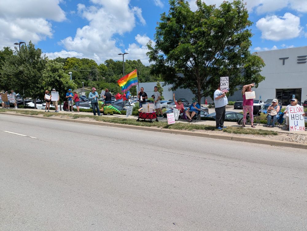 Protesters in front of a Tesla lot, and the protesters look badass as fuck