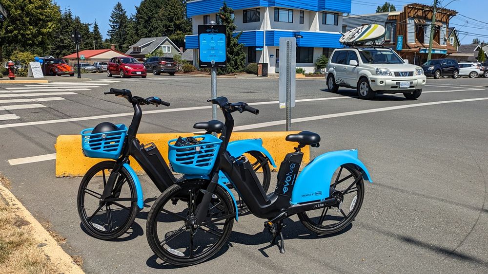 Two Evolve e-bikes parked on the side of the road by a crosswalk in Courtenay, BC.