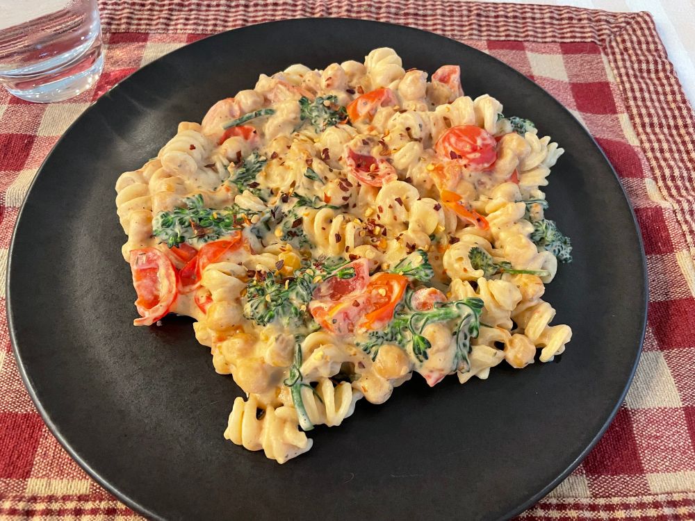Pasta in a cashew cream sauce with broccolini, cherry tomatoes and chili flakes