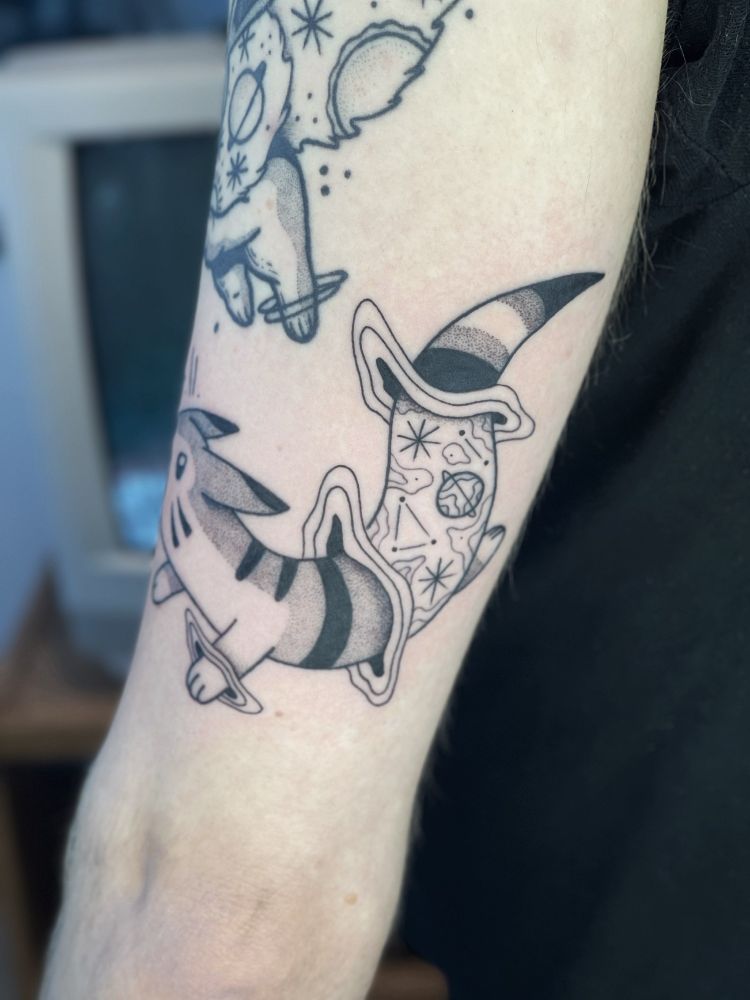 A tattoo of furret! They're going through a portal and seems to be barking planets