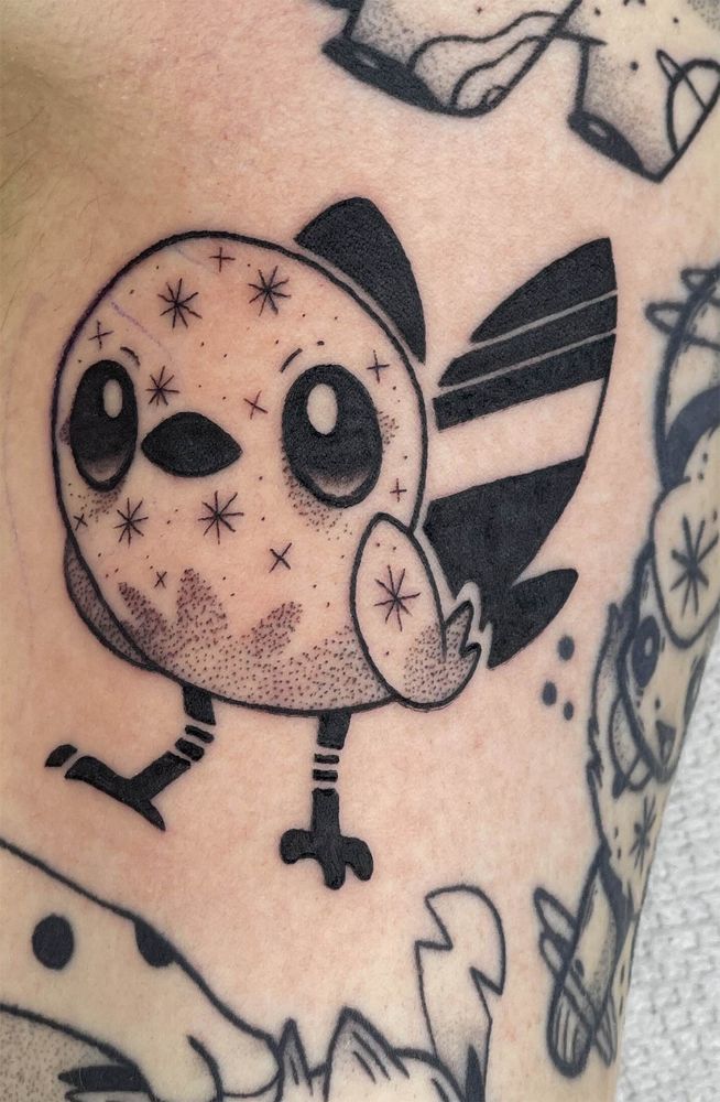A fletchling tattoo, standing with stars all around their body