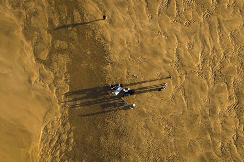 Zoomed out view of scientists sampling a beach on the TREC expedition