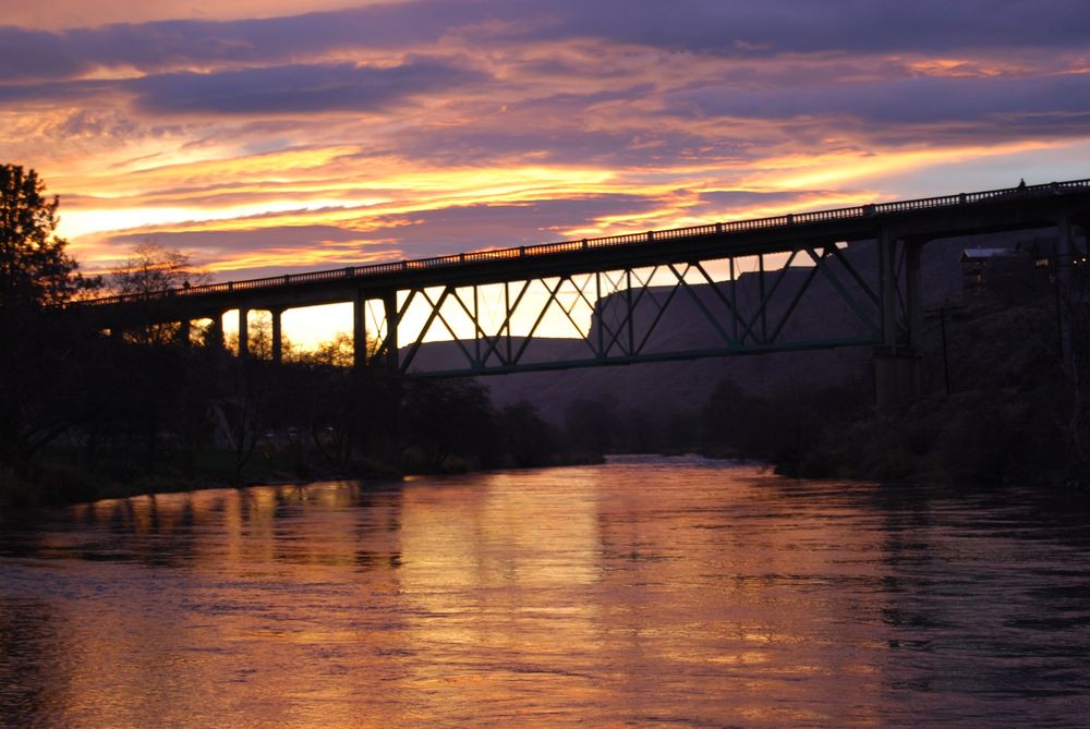 Bridge at angle above a river with sunset in background 