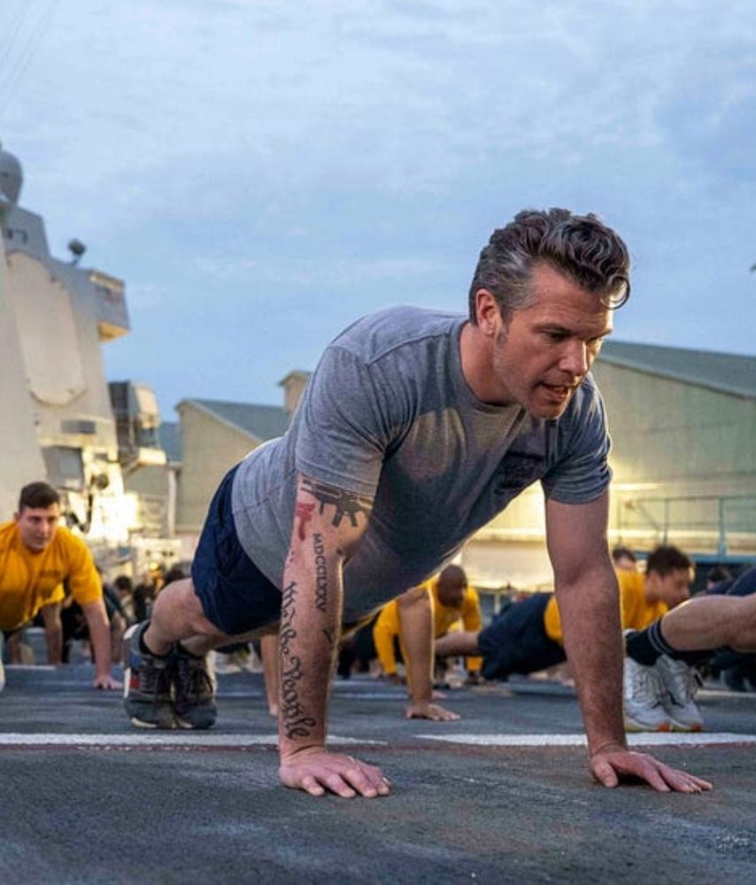 Pete Hegseth doing pushups with sailors