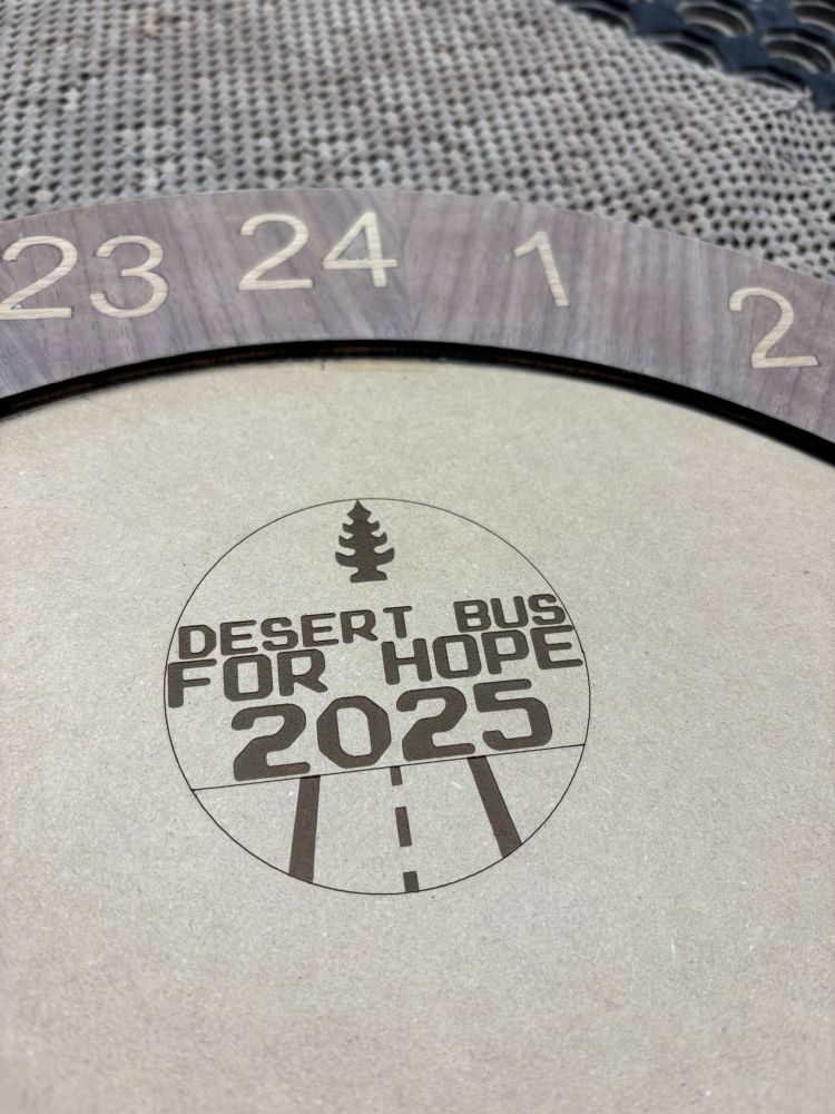 The desert bus for hope 2025 logo laser cut onto the clock. 