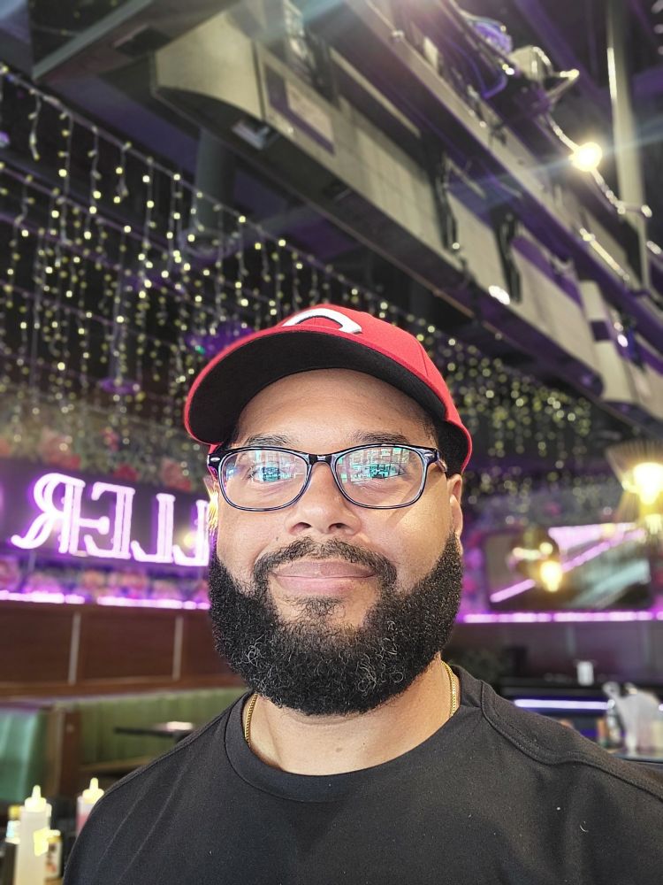 A 43 year old man looking at the camera in a bar