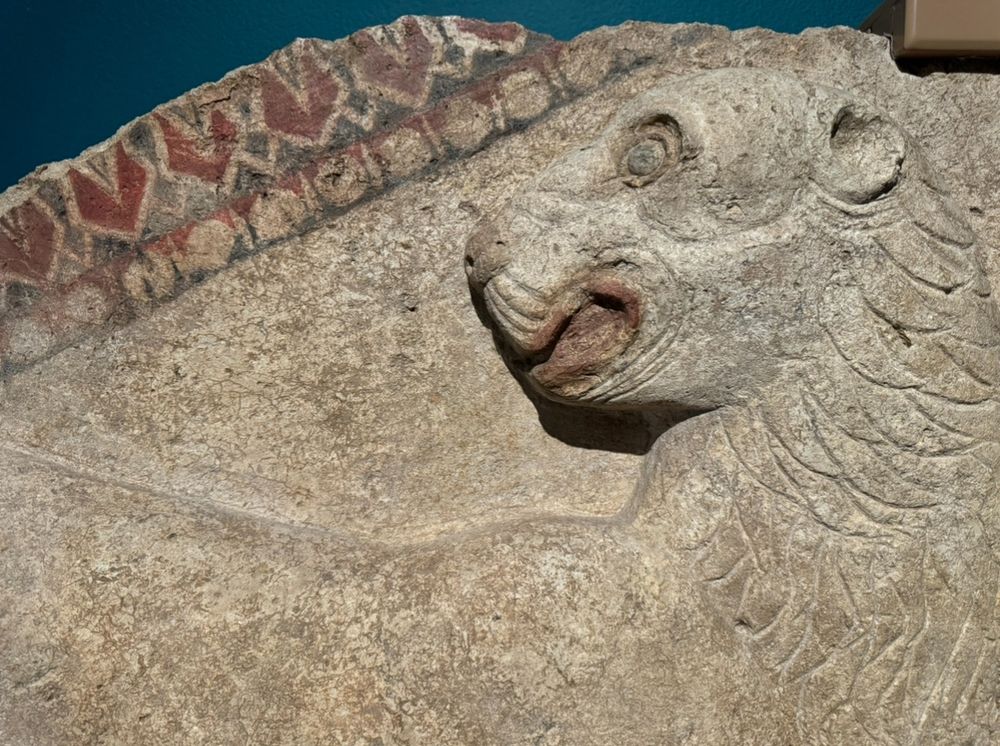 Detail of a polychrome relief with a lion, wide eyed