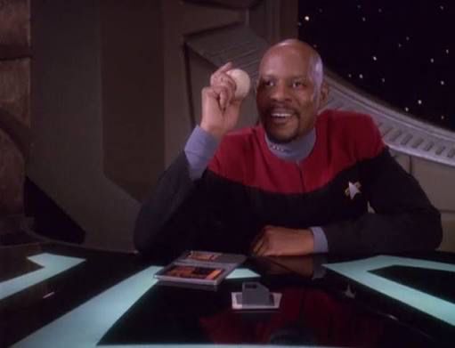 Captain Sisko delightedly grinning with a baseball 
