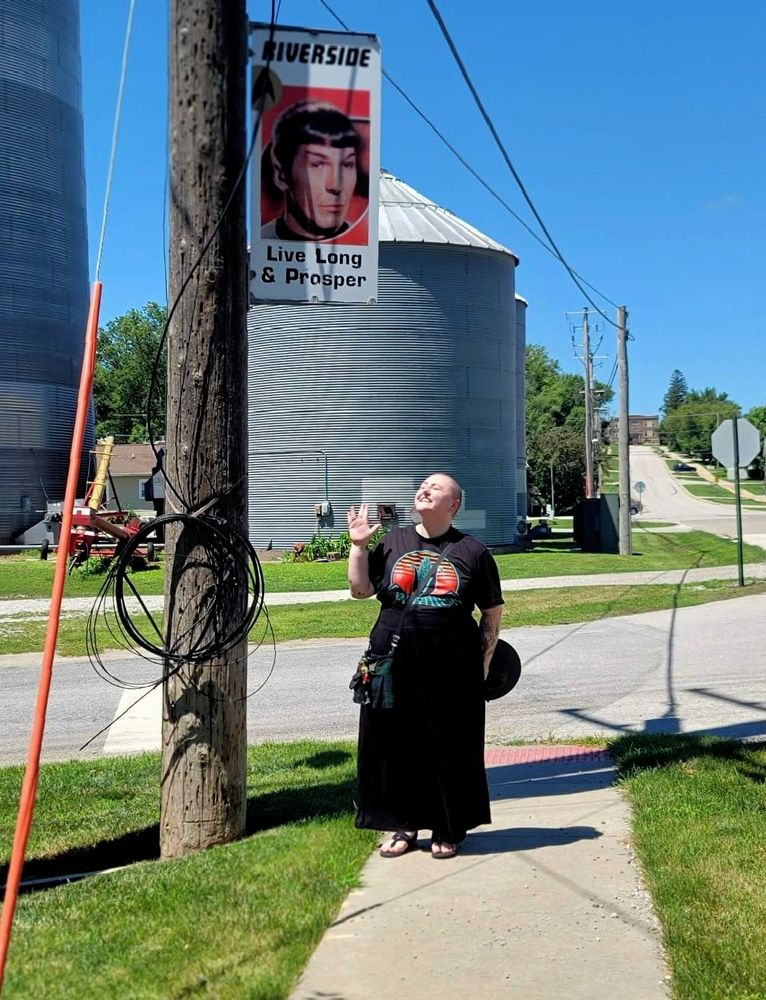 Me in Riverside Iowa beneath a banner with Spock on it that says "Live Long and Prosper."