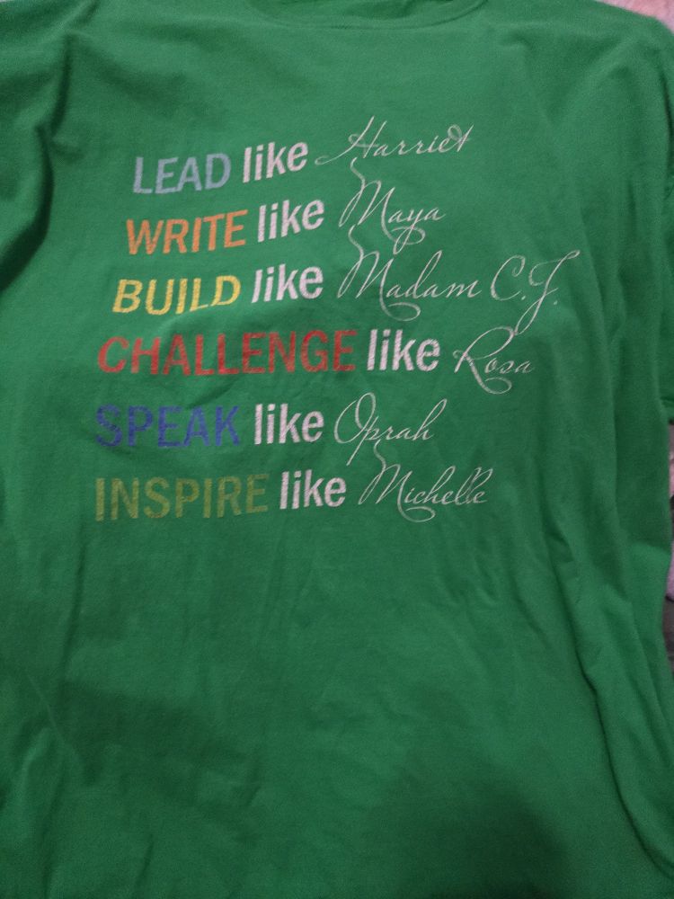 Green Tshirt with the words:
Lead like Harriet
Write like Maya
Build like Madam C.J.
Challenge like Rosa
Speak like Oprah
Inspire like Michelle 