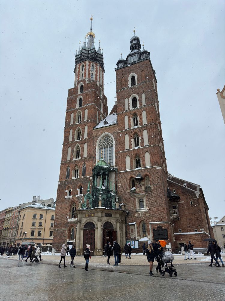 St. Mary's Basilica - is a tall gothic style church in red brick and white. On top is ornate decorative roof, with gold adornments 