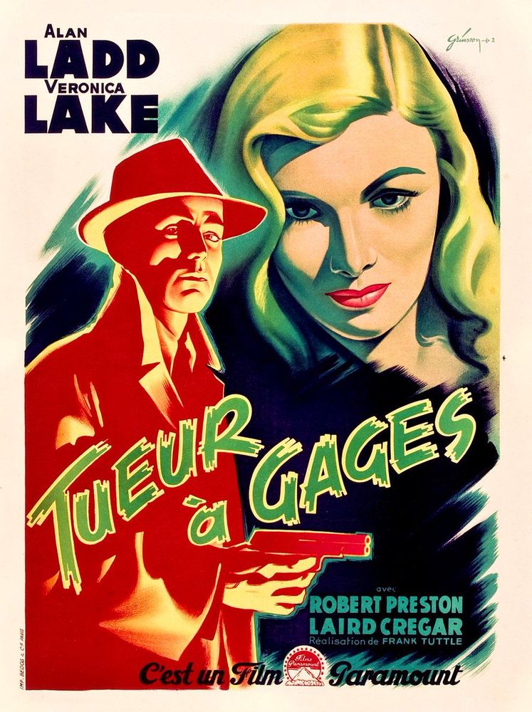 Alan Ladd brandishes a gun as Veronica Lake hovers above him