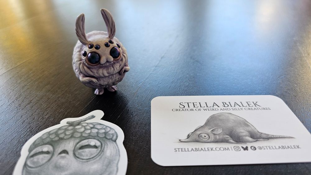 Little moth bunny figure ( hand painted resin print), and a funny looking acorn sticker beside Stella's business card.