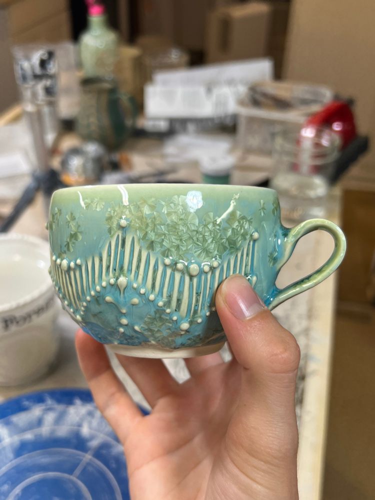 A turquoise crystalline teacup, fresh out of the kiln 