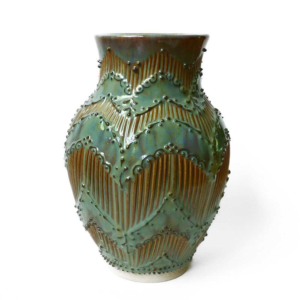 A green and blue vase with a zig zag pattern created by slip trailing and carved lines