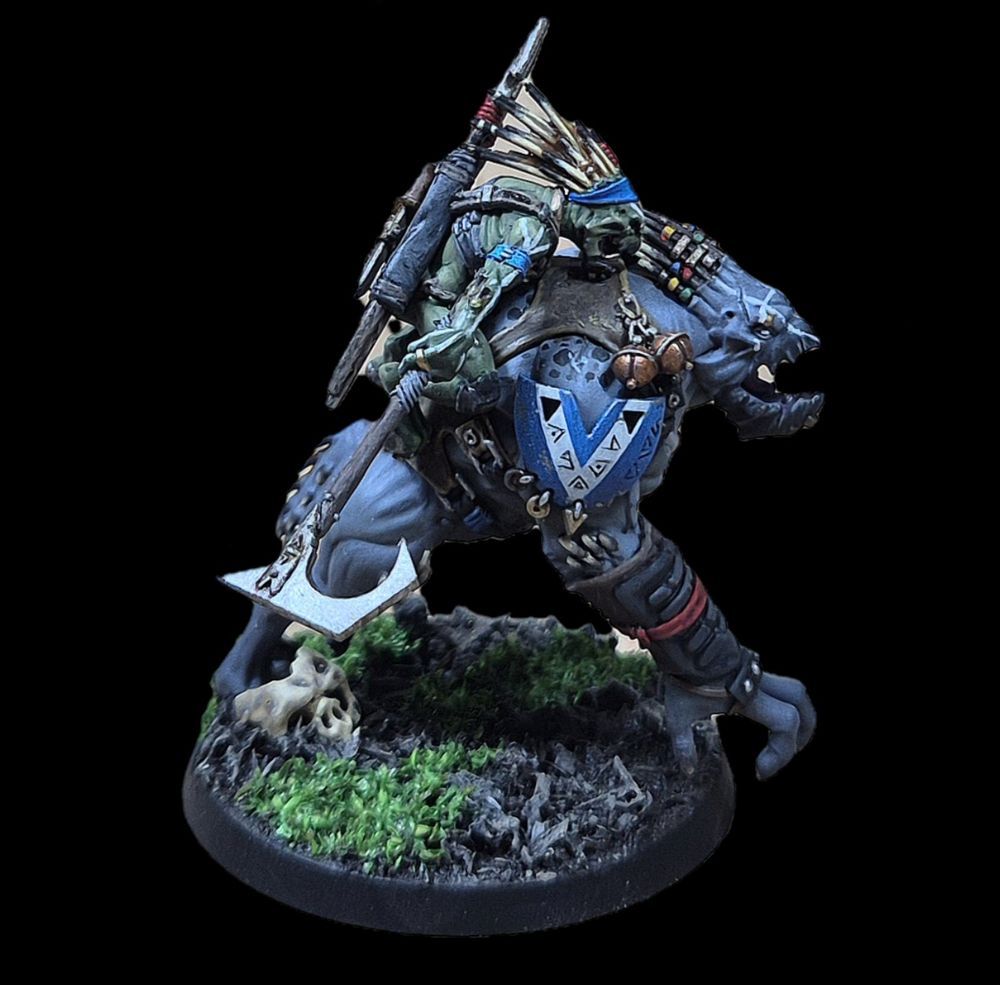 A side on image of a Kroot Rampager, painted grey with a green rider, with a blue shoulderpad on the Rampager with white chevron and freehand kroot symbols on. The Kroot and Rampager both have white warpaint.