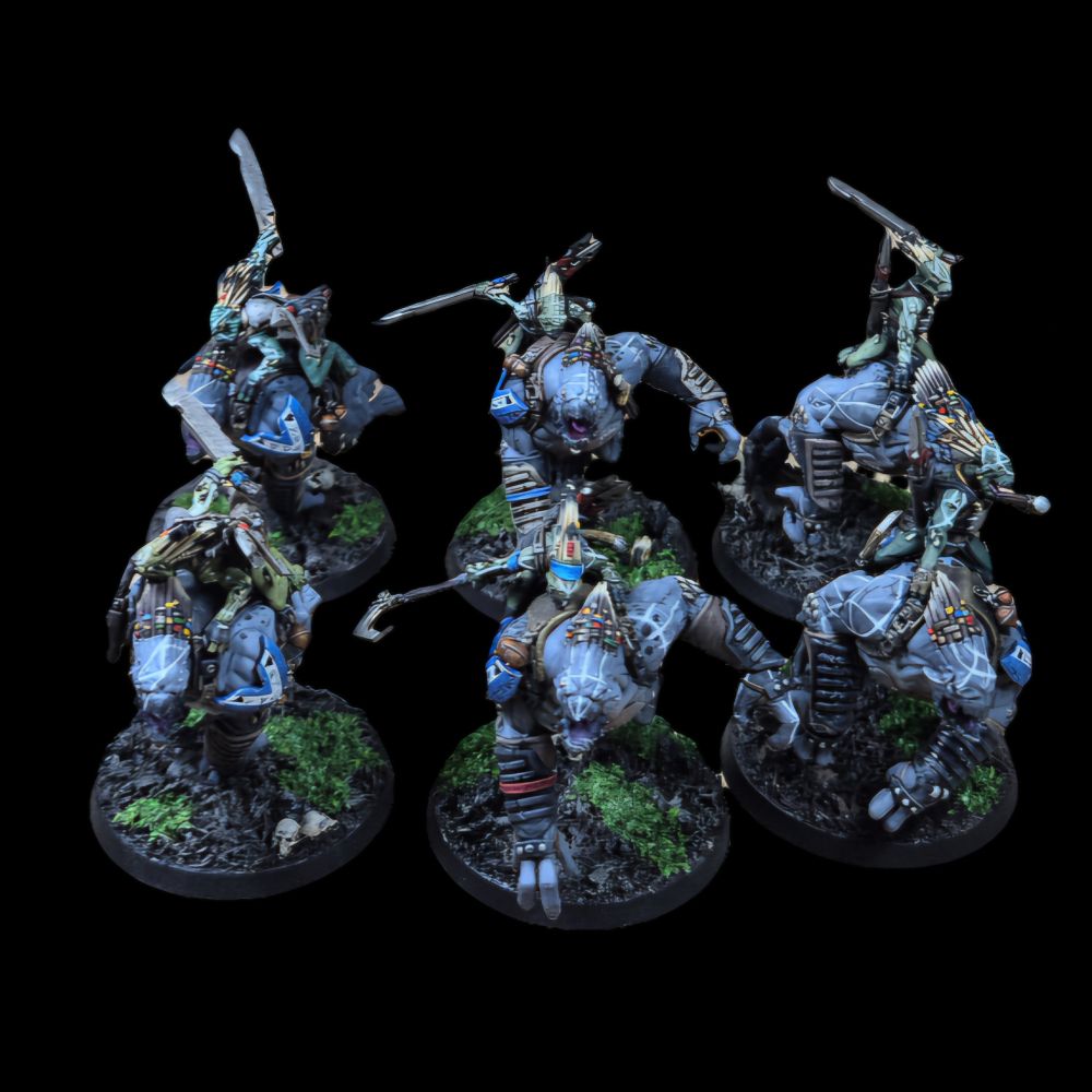 An image of 6 Kroot Rampagers, painted grey with riders in different green shades, on brown and green jungle bases The Kroot and Rampagers all have white warpaint, with blue shoulderpads on the Rampagers with Kroot symbols on.