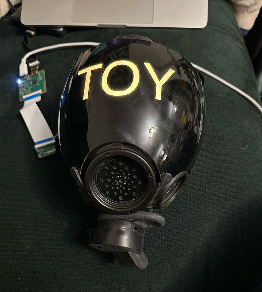 MSA gasmask with an OLED showing the word TOY
