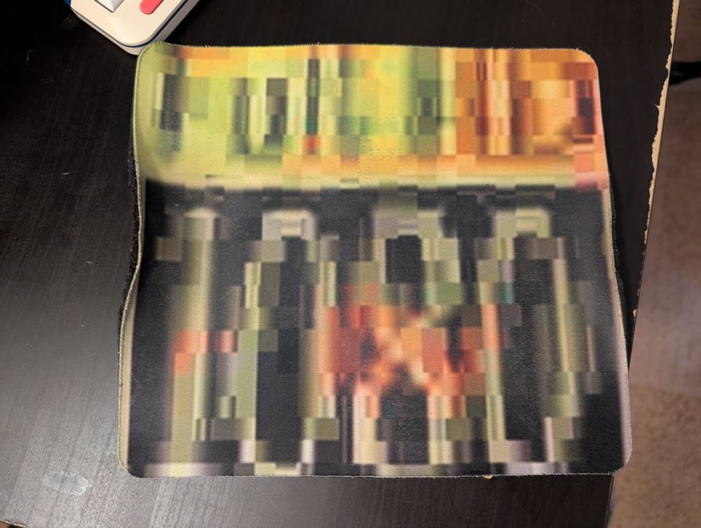 A mousepad showing a "Full HD - 1080" label printed in exaggeratedly low quality.