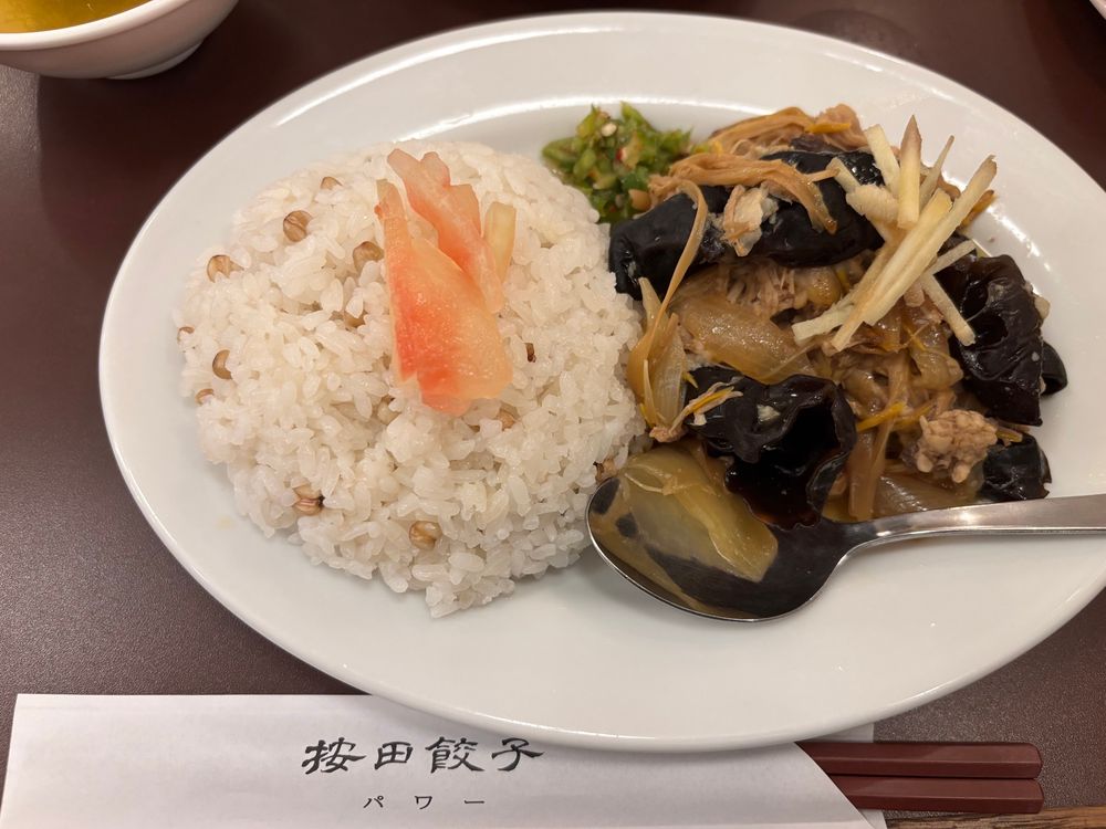 按田餃子のラゲーライス　左側におわんがたにご飯が盛られ、右側にきぐらげと豚肉と玉ねぎを煮たおかずがよそわれている